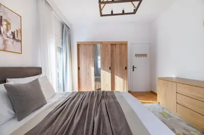 a bedroom with a bed with a dresser and a window at Sunlit 3BDR Family APT, Near Sea & City Center! in Athens