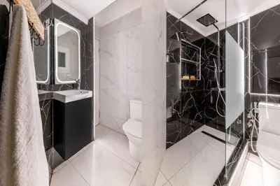 a black and white bathroom with a toilet and a sink at Sunlit 3BDR Family APT, Near Sea & City Center! in Athens