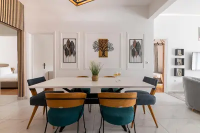 a dining room with a white table and chairs at Sunlit 3BDR Family APT, Near Sea & City Center! in Athens