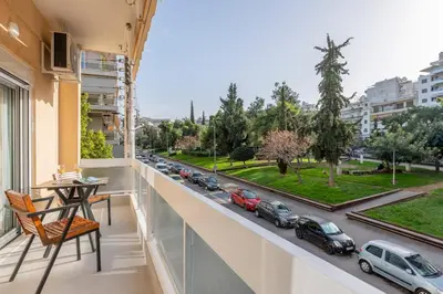 a balcony with a table and a view of a street at Sunlit 3BDR Family APT, Near Sea & City Center! in Athens