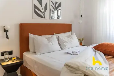 a bedroom with a large bed with white pillows at Sunlit Balcony Family APT Whirpool & Netflix in Athens