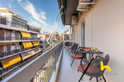 a balcony with a table and chairs on a building at Sunlit Balcony Family APT Whirpool & Netflix in Athens