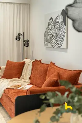 a living room with a couch with orange pillows at Sunlit Balcony Family APT Whirpool & Netflix in Athens
