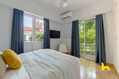 a bedroom with a bed and a large window at Retro Radiance Artistic Haven Near Acropolis in Athens