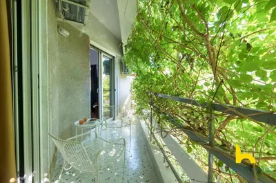 a balcony with a tree on the side of a building at Retro Radiance Artistic Haven Near Acropolis in Athens