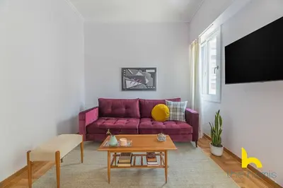 a living room with a purple couch and a table at Retro Radiance Artistic Haven Near Acropolis in Athens