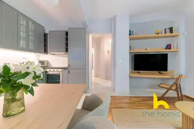 a kitchen and dining room with a table and a tv at Sun Splashed Sanctum w Green Patio, Acropolis in Athens