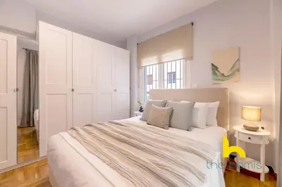 a white bedroom with a large white bed with pillows at Sun Splashed Sanctum w Green Patio, Acropolis in Athens