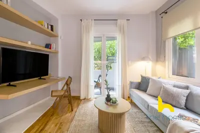a living room with a couch and a tv at Sun Splashed Sanctum w Green Patio, Acropolis in Athens