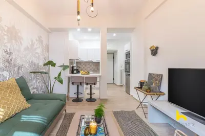 a living room with a green couch and a kitchen at The Urban Jungle Escape Corner APT Near Acropolis in Athens