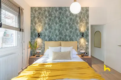 a bedroom with a large bed with a yellow blanket at The Urban Jungle Escape Corner APT Near Acropolis in Athens