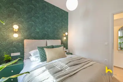 a bedroom with a bed with a green wall at The Urban Jungle Escape Corner APT Near Acropolis in Athens