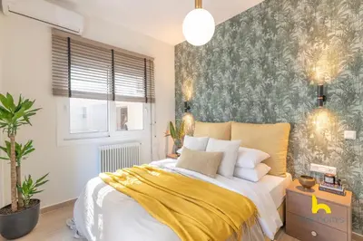 a bedroom with a large bed with a yellow blanket at The Urban Jungle Escape Corner APT Near Acropolis in Athens