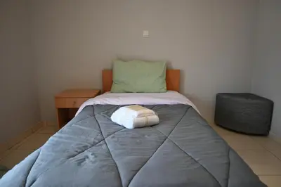 a bed with a pillow on it in a room at Christoffer Mpournazi Penthouse in Athens