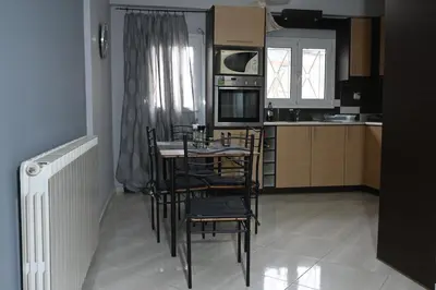 a kitchen with chairs and a table and a microwave at Christoffer Mpournazi Penthouse in Athens