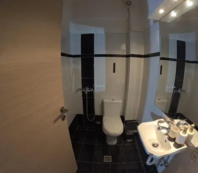 a bathroom with a white toilet and a sink at Christoffer Mpournazi Penthouse in Athens