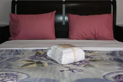 a bed with two pink pillows and a white bag on it at Christoffer Mpournazi Penthouse in Athens