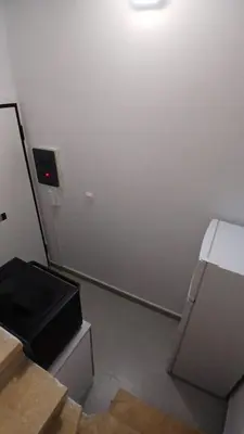 a room with a white wall and a refrigerator at Harbor View Apartment Athens in Piraeus