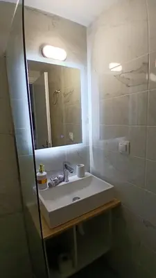 a bathroom with a sink and a mirror at Harbor View Apartment Athens in Piraeus