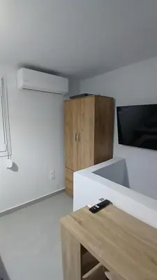 a kitchen with a white counter and a wooden cabinet at Harbor View Apartment Athens in Piraeus