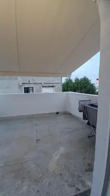 an empty room with a white wall at Harbor View Apartment Athens in Piraeus