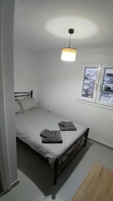 a bedroom with a bed with two towels on it at Harbor View Apartment Athens in Piraeus