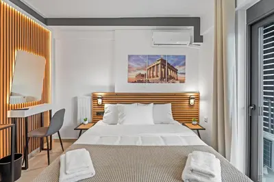 a bedroom with a bed and a desk with a chair at Athens Vein in Athens