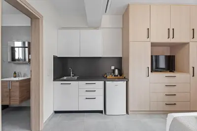 a kitchen with white cabinets and a sink at Athens Vein in Athens
