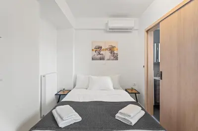 a bedroom with a bed with two towels on it at Athens Vein in Athens