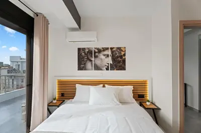 a bedroom with a bed and a painting on the wall at Athens Vein in Athens