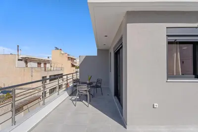a balcony with a table and chairs on a building at Athens Vein in Athens