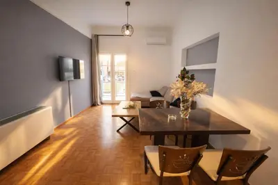 a living room with a dining room table with chairs at Zwgrafou Deluxe For 4 Pers in Athens