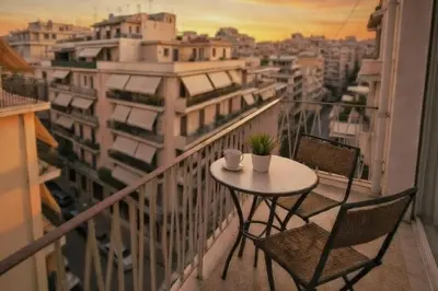 a table and chairs on a balcony with a view of a city at Zwgrafou Deluxe For 4 Pers in Athens