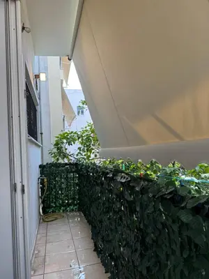 a green wall with plants on the side of a building at Bakopoulos resort στο Μπουρνάζι in Athens