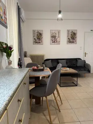 a kitchen and living room with a table and a couch at Bakopoulos resort στο Μπουρνάζι in Athens