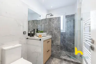 a bathroom with a toilet and a glass shower at Sunny Athenian Oasis Spacious Family Haven! in Athens