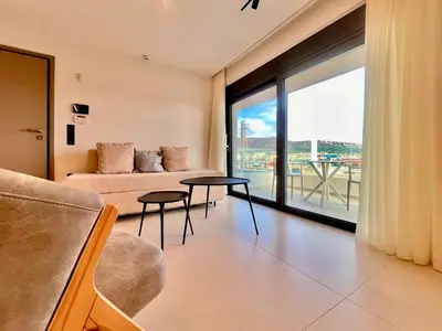 a living room with a couch and a large window at Penthouse with private pool and unlimited Sea View in Glyfádas