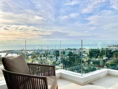 a balcony with a chair and a large window at Penthouse with private pool and unlimited Sea View in Glyfádas