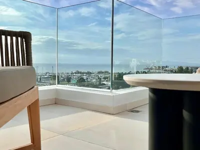 a room with a large window with a tub and a table at Penthouse with private pool and unlimited Sea View in Glyfádas