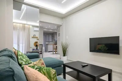 a living room with a blue couch and a table at Central apartment in Piraeus in Piraeus