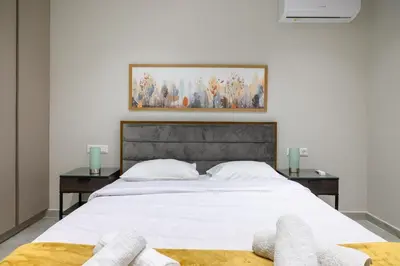 a bedroom with a large white bed with two tables at Central apartment in Piraeus in Piraeus