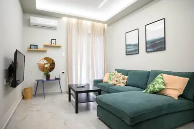 a living room with a green couch and a table at Central apartment in Piraeus in Piraeus