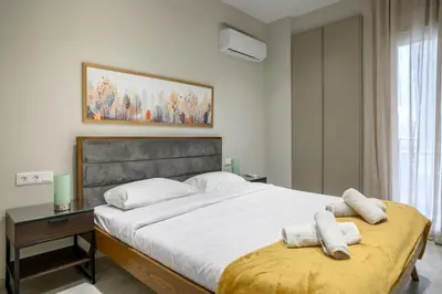 a bedroom with a large bed with two towels on it at Central apartment in Piraeus in Piraeus