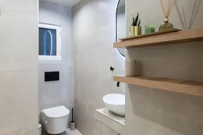 a small bathroom with a toilet and a sink at AVM Suites - Grand Thissio Prestige Residence in Athens