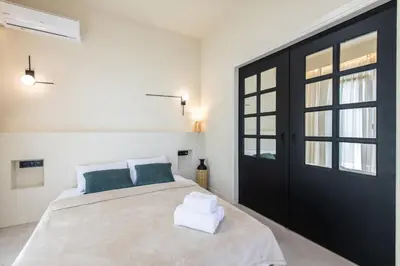 a bedroom with a bed with a black door at AVM Suites - Grand Thissio Prestige Residence in Athens