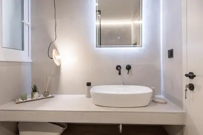 a bathroom with a white sink and a mirror at AVM Suites - Grand Thissio Prestige Residence in Athens