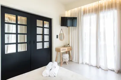 a bedroom with a black door and a bed with white towels at AVM Suites - Grand Thissio Prestige Residence in Athens