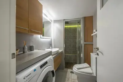 a bathroom with a washing machine and a toilet at Cozy Seaside Apartment in Aphrodite Bay, Piraeus in Piraeus