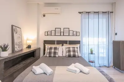 a bedroom with a large bed with two pillows at Cozy Seaside Apartment in Aphrodite Bay, Piraeus in Piraeus