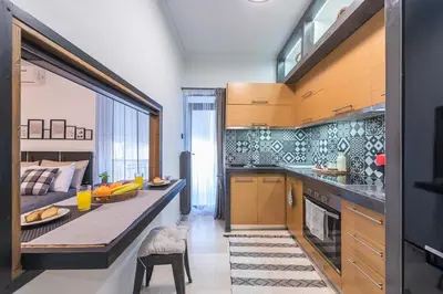 a kitchen with a table and a bed in a room at Cozy Seaside Apartment in Aphrodite Bay, Piraeus in Piraeus